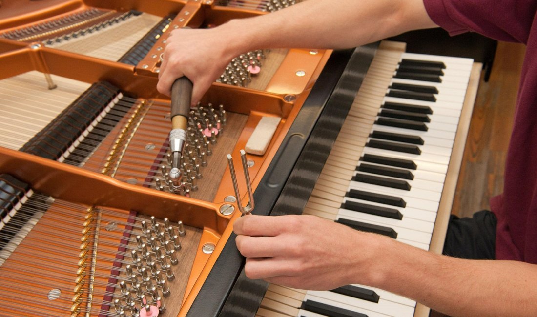 Piano technician checking a secondhand reconditioned piano